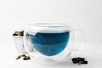 Photo of Delicious butterfly pea flower tea on white tiled table