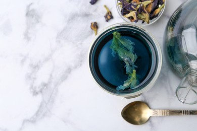 Photo of Delicious butterfly pea flower tea on white marble table, flat lay. Space for text