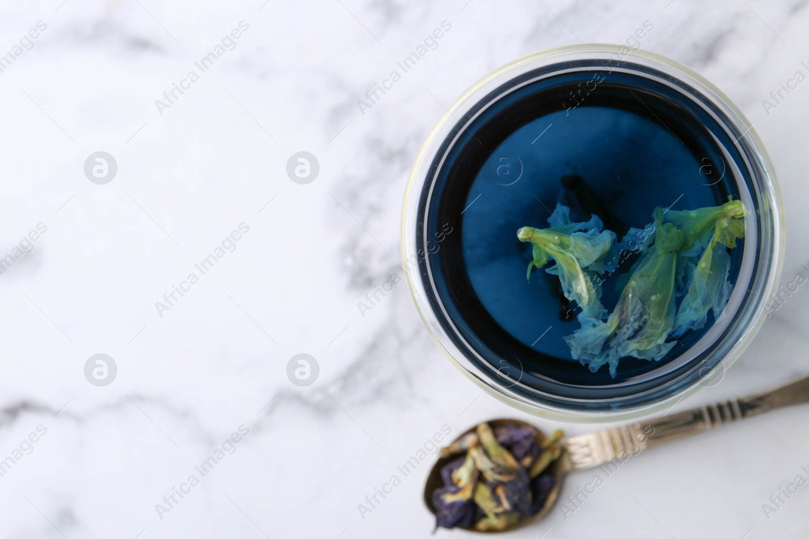Delicious butterfly pea flower tea on white marble table, top view. Space for text Photo of Delicious butterfly pea flower tea on white marble table, top view. Space for text