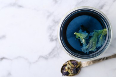 Photo of Delicious butterfly pea flower tea on white marble table, top view. Space for text