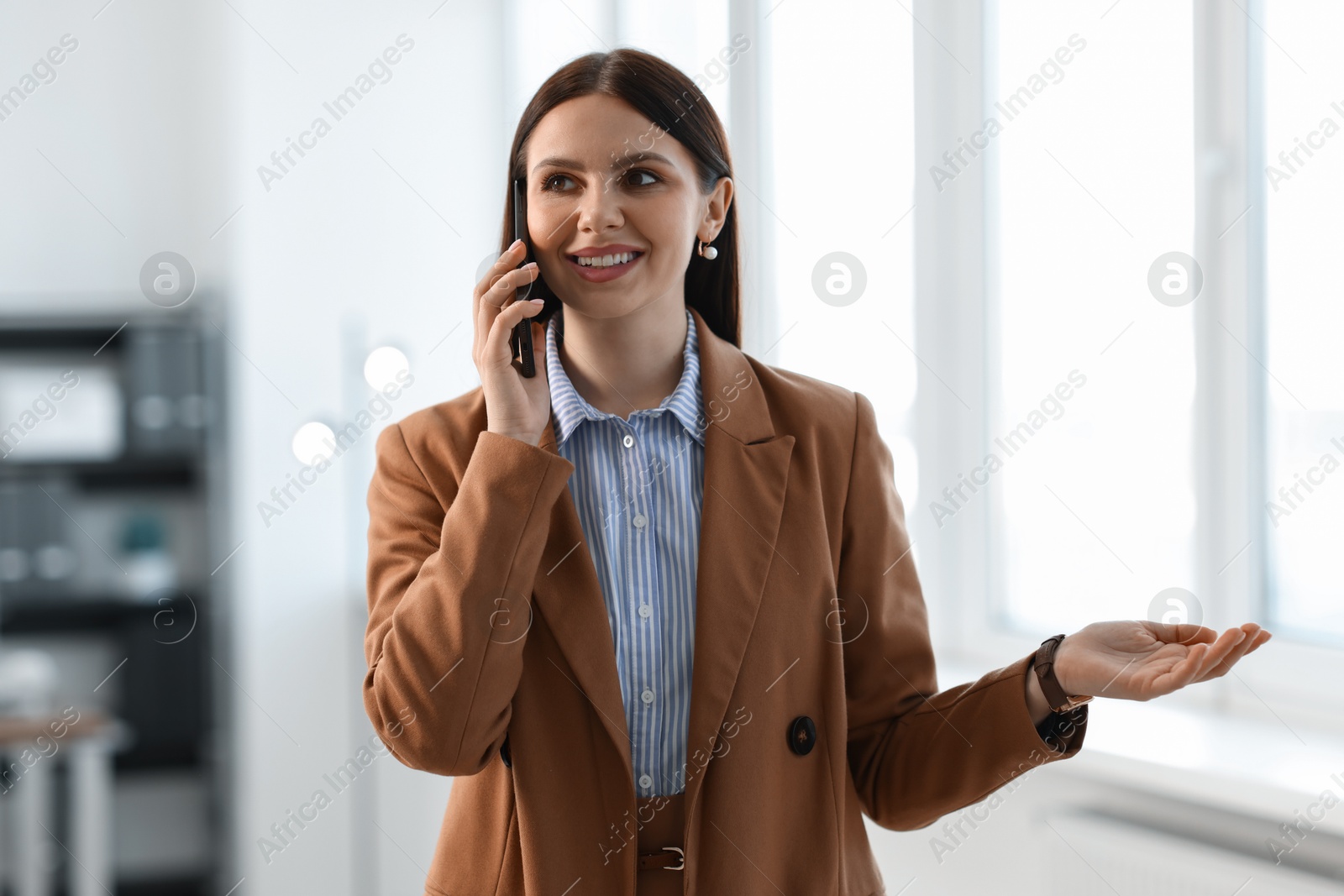 Photo of Portrait of banker talking on smartphone in office