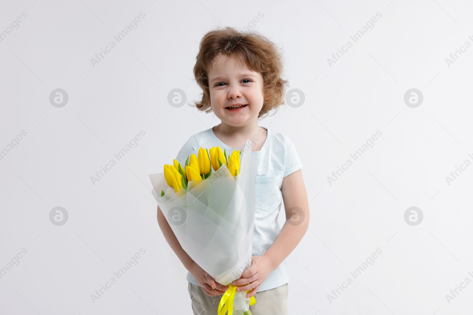 Photo of Cute little boy with bouquet of tulips on white background