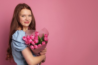 Photo of Beautiful teenage girl with bouquet of tulips on pink background, space for text