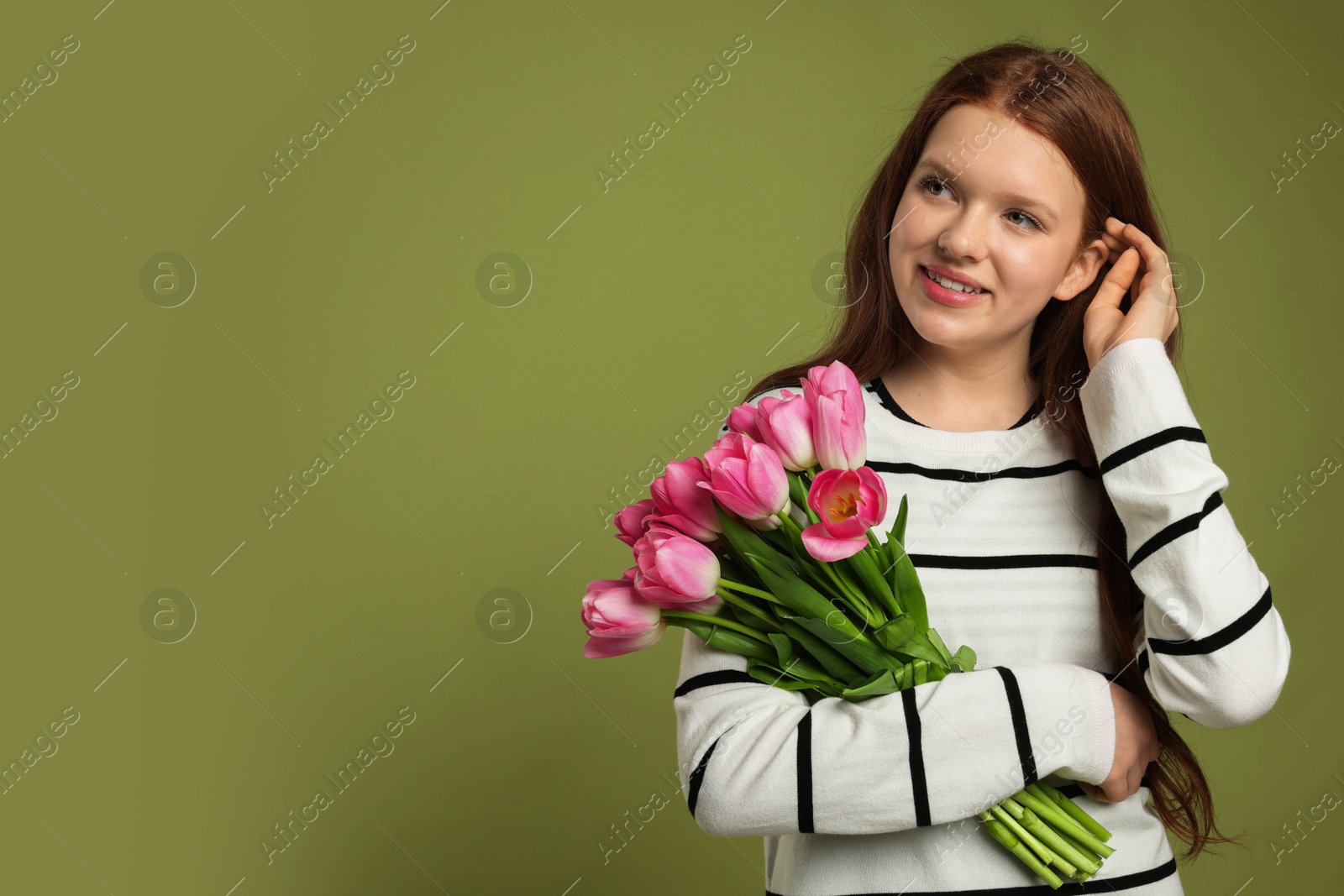 Photo of Beautiful teenage girl with bouquet of tulips on olive background, space for text