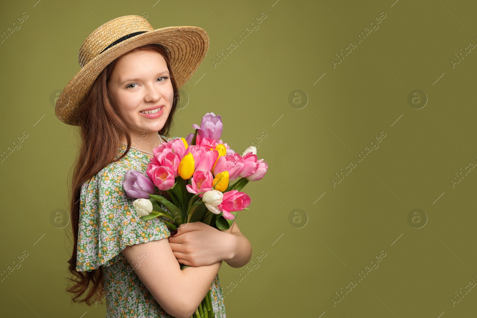 Photo of Beautiful teenage girl with bouquet of tulips on olive background, space for text