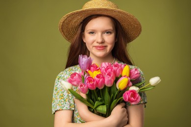 Photo of Beautiful teenage girl with bouquet of tulips on olive background