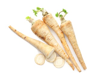 Photo of Whole and cut fresh parsley roots isolated on white, top view