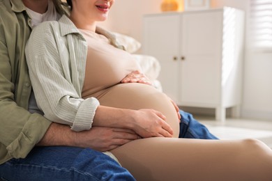 Pregnant woman and her husband at home, closeup