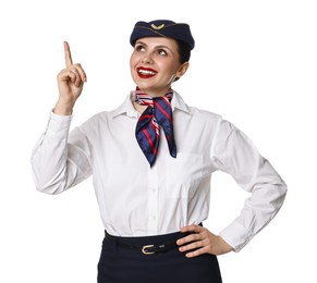 Smiling stewardess pointing upwards on white background