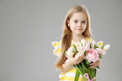 Photo of Cute little girl with bouquet of beautiful spring flowers on gray background, space for text