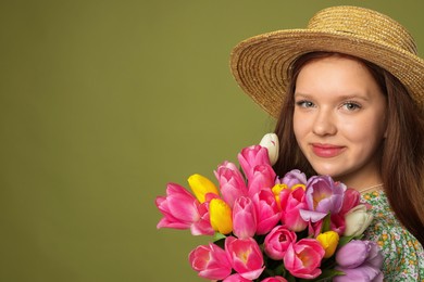 Photo of Beautiful teenage girl with bouquet of tulips on olive background, space for text