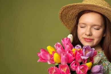 Photo of Beautiful teenage girl with bouquet of tulips on olive background, space for text