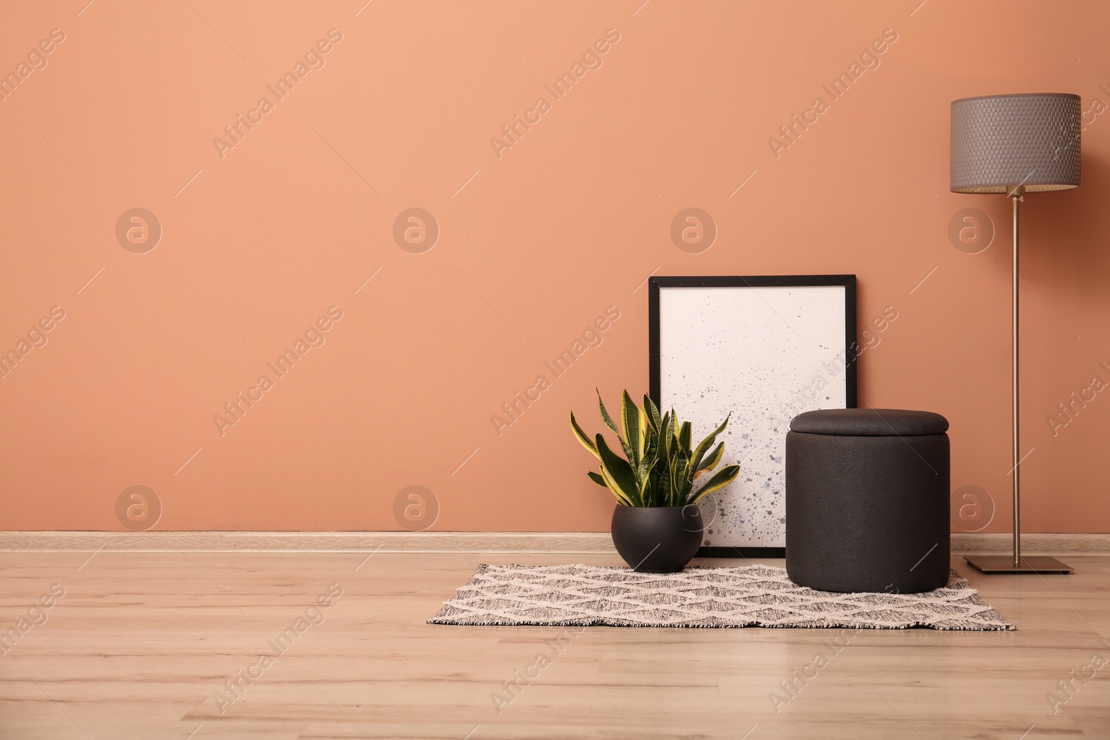 Photo of Comfortable pouf, plant, lamp and picture near pale pink wall indoors, space for text