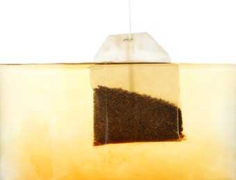 Photo of Putting tea bag into glass cup on white background, closeup