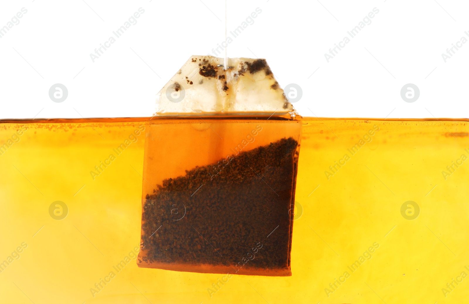 Photo of Putting tea bag into glass cup on white background, closeup