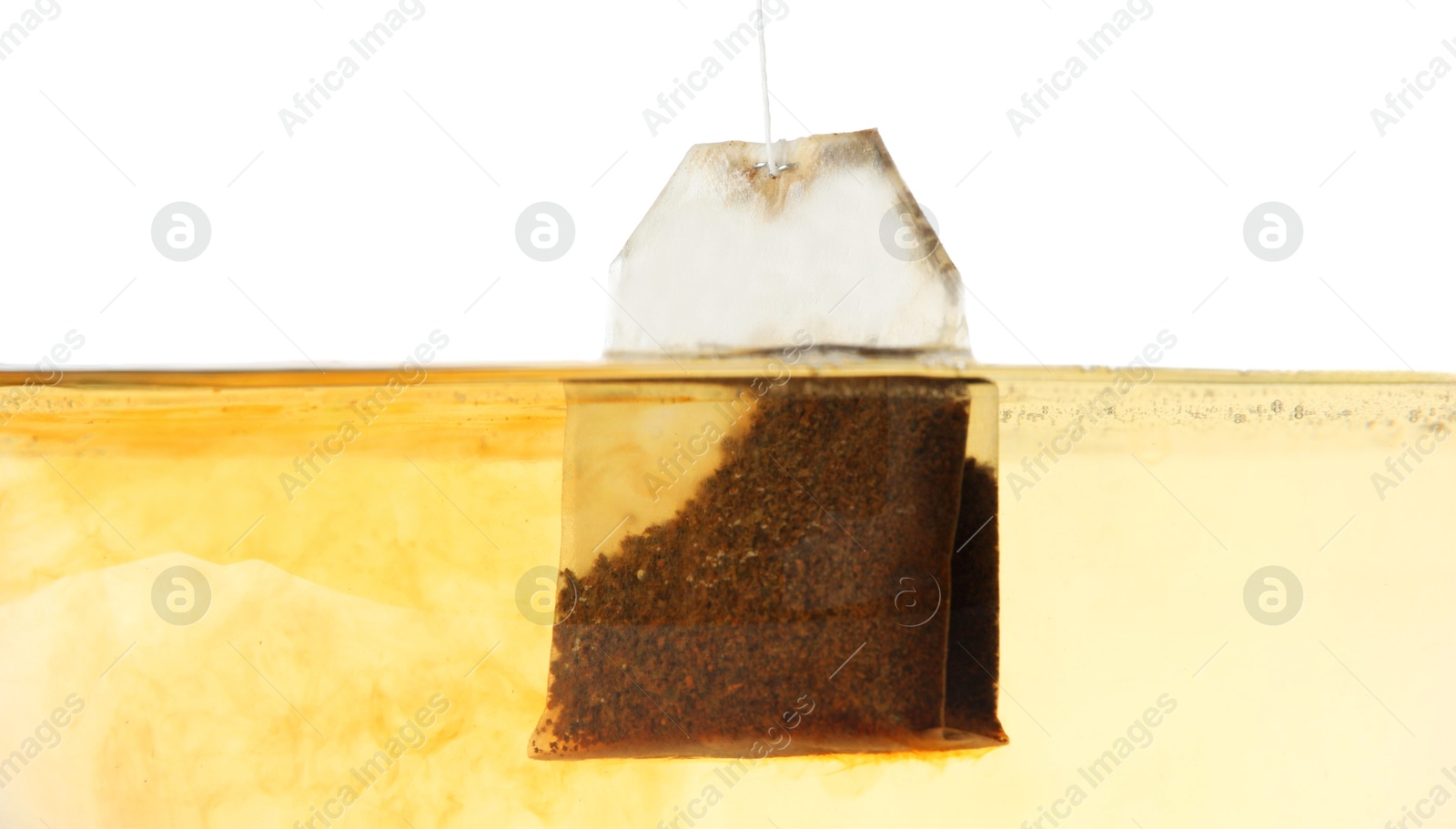 Photo of Putting tea bag into glass cup on white background, closeup