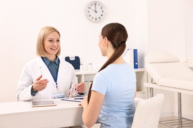 Photo of Weight loss. Smiling nutritionist consulting patient at table in clinic