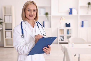 Photo of Weight loss. Smiling nutritionist with clipboard in clinic, space for text