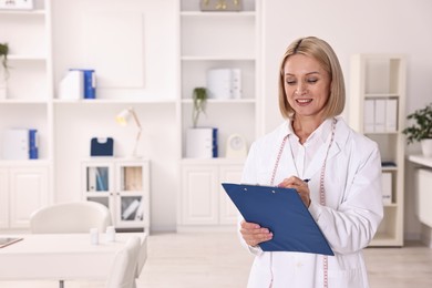 Photo of Weight loss. Smiling nutritionist with clipboard in clinic, space for text