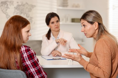 Photo of Difficult teenager. Mother and daughter having consultation with psychologist in office, selective focus