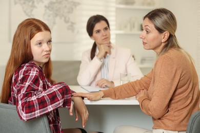 Photo of Difficult teenager. Mother and daughter having consultation with psychologist in office, selective focus