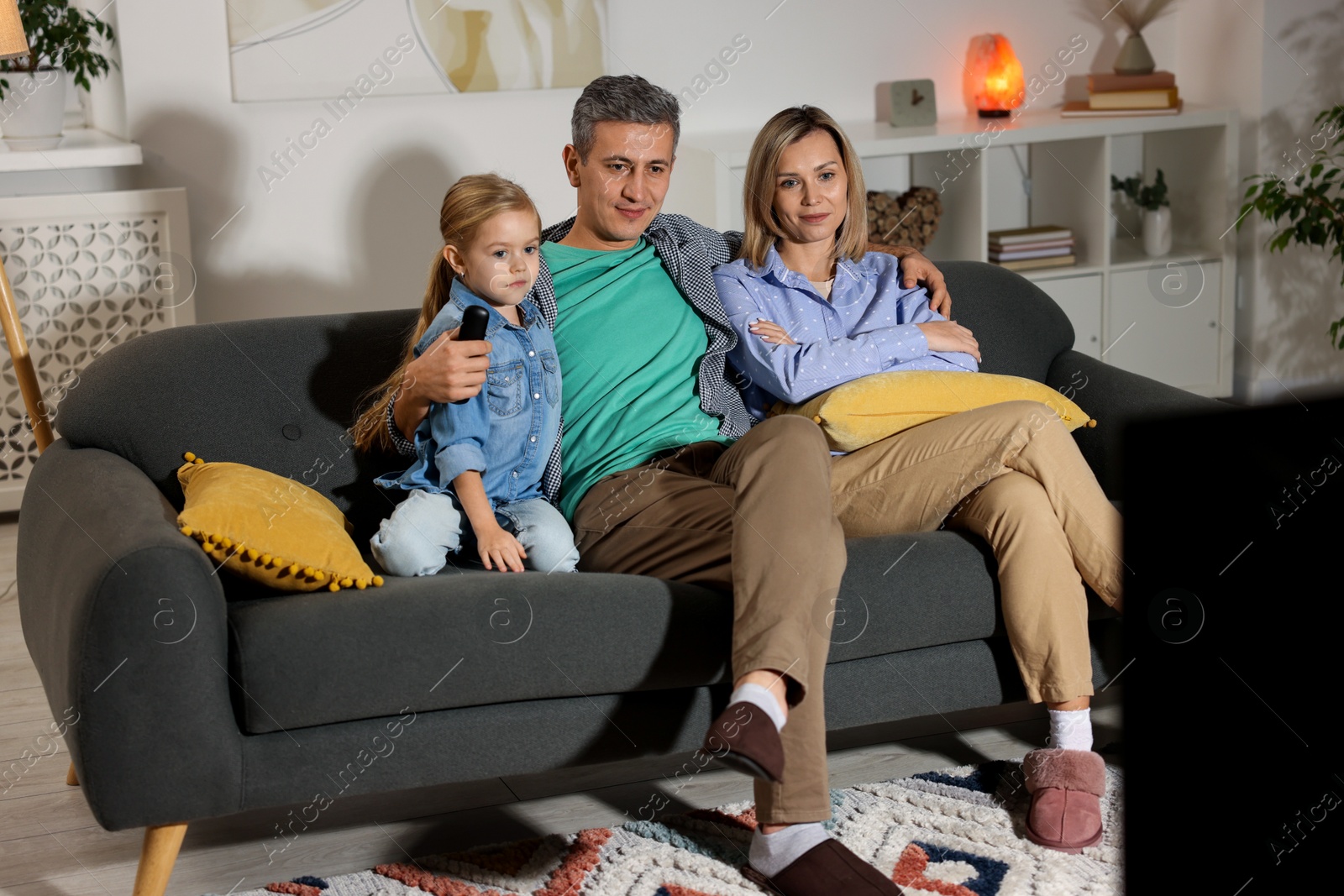 Photo of Family watching TV on sofa at home