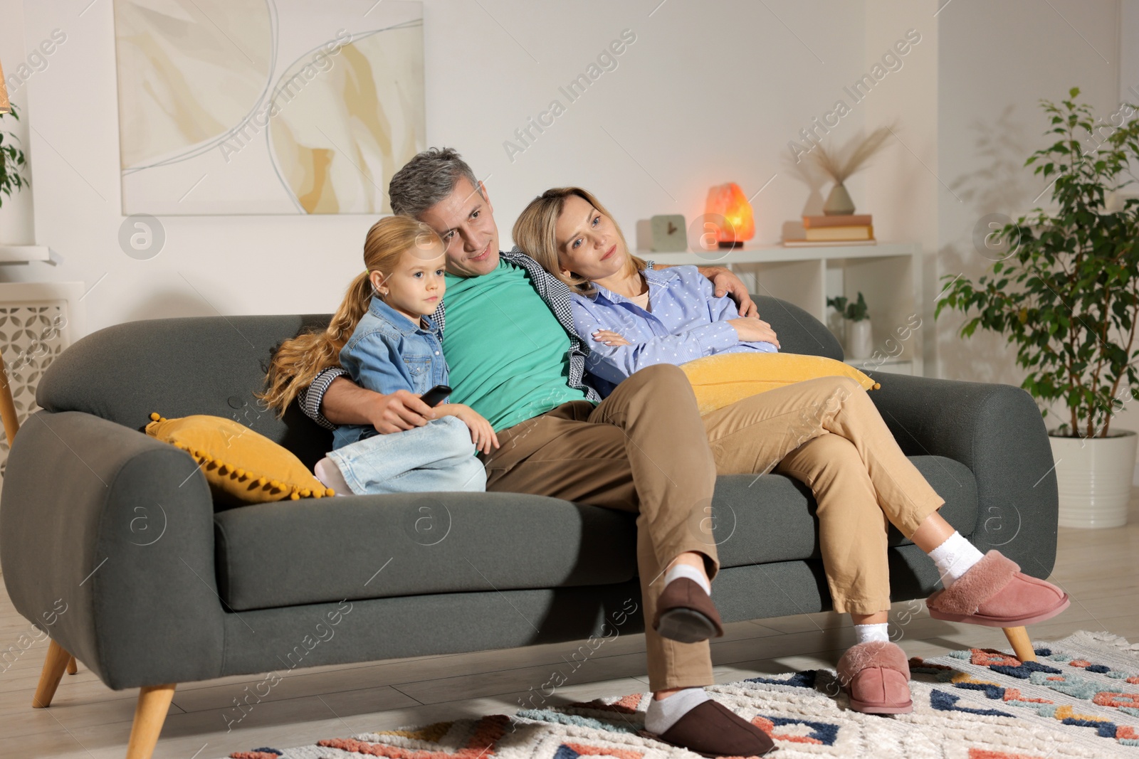 Photo of Family watching TV on sofa at home