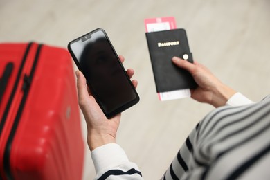 Photo of Traveller with passport, flight tickets and smartphone indoors, above view