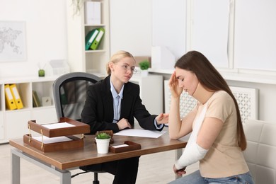 Photo of Injured woman having meeting with lawyer in office