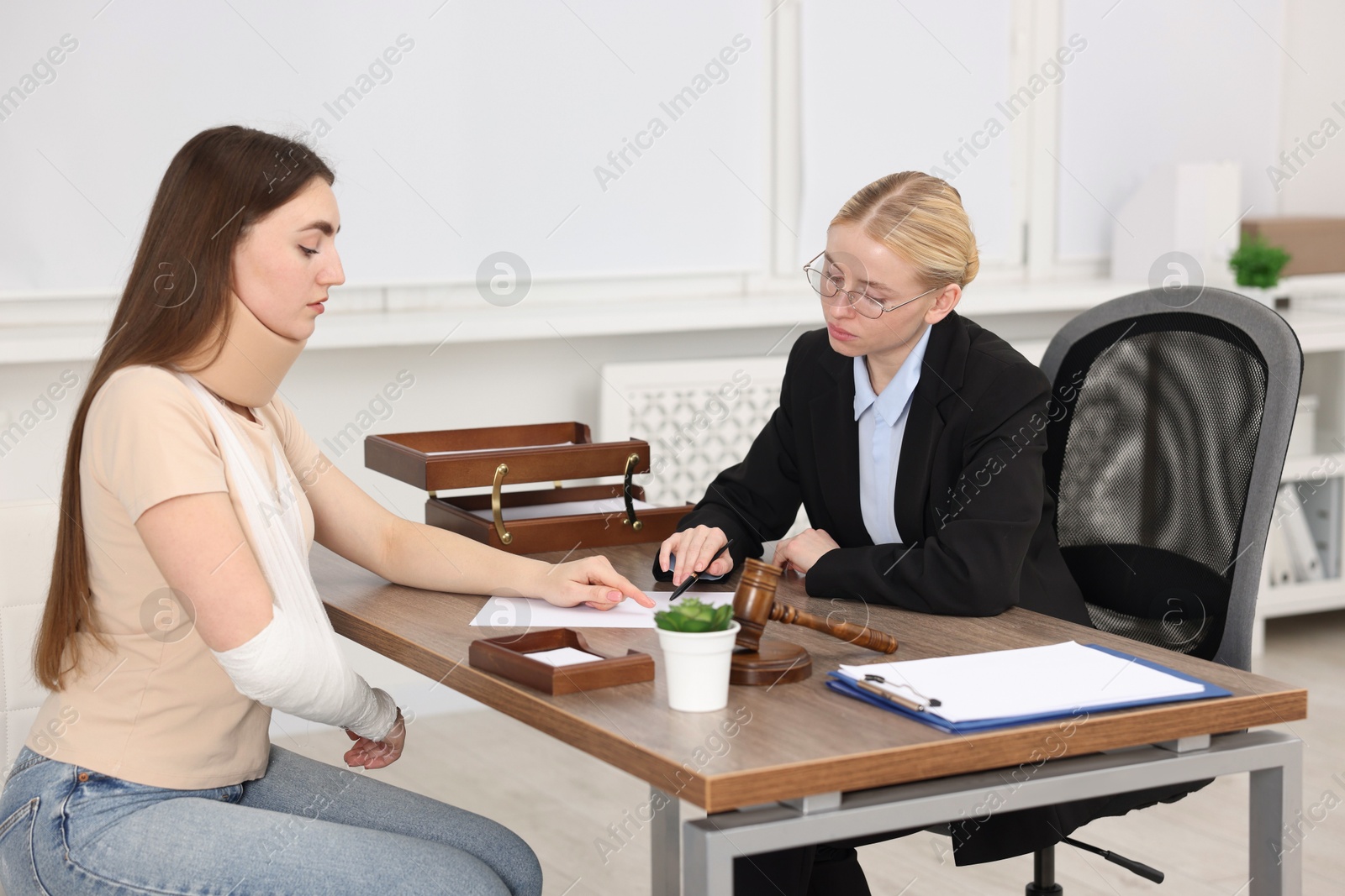 Photo of Injured woman having meeting with lawyer in office