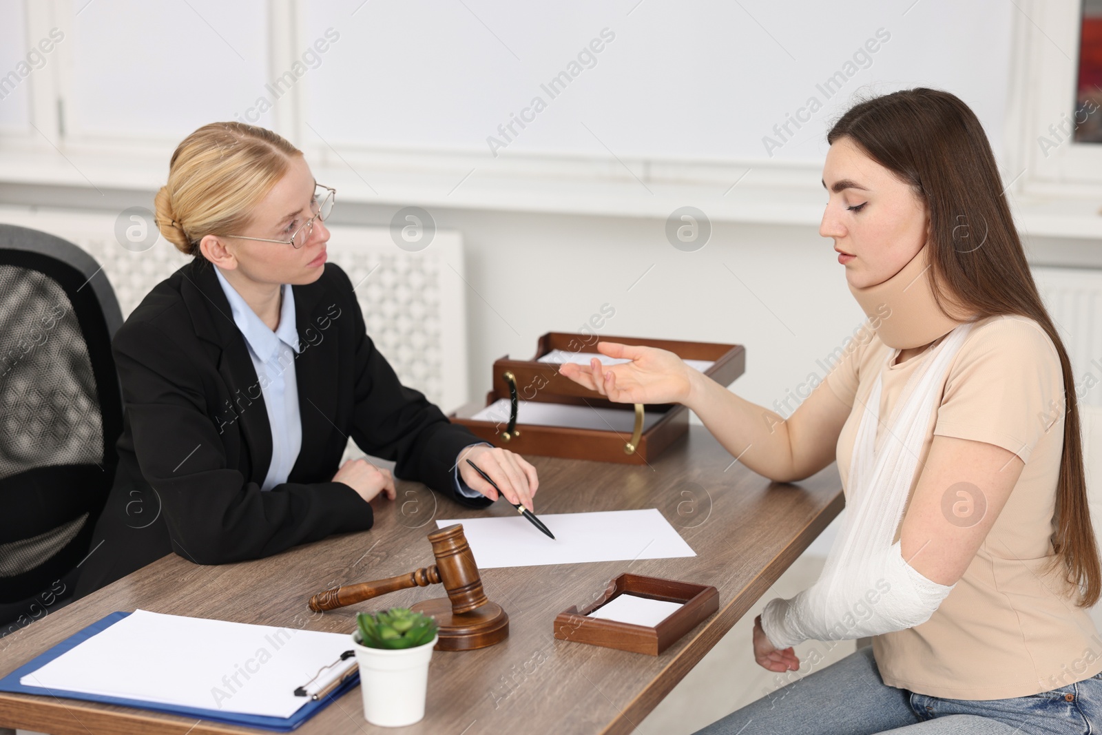 Photo of Injured woman having meeting with lawyer in office