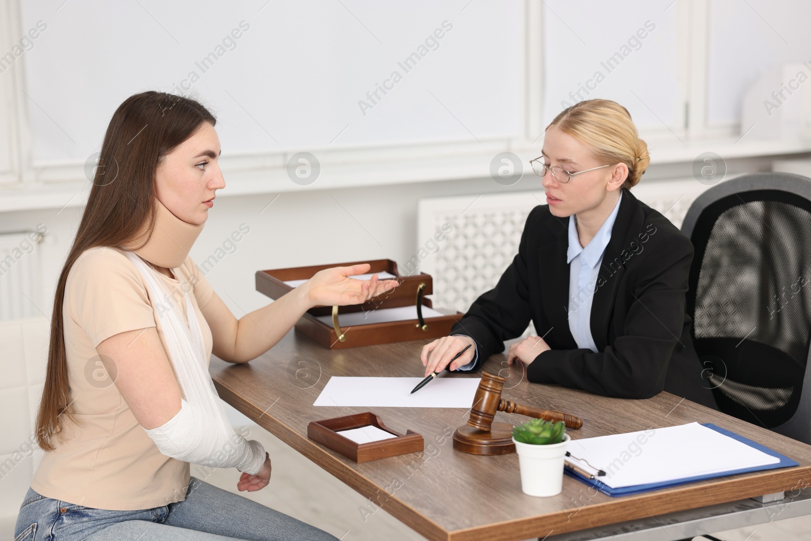 Photo of Injured woman having meeting with lawyer in office