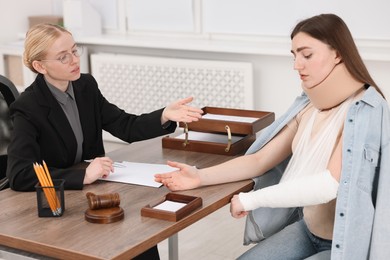 Photo of Injured woman having meeting with lawyer in office