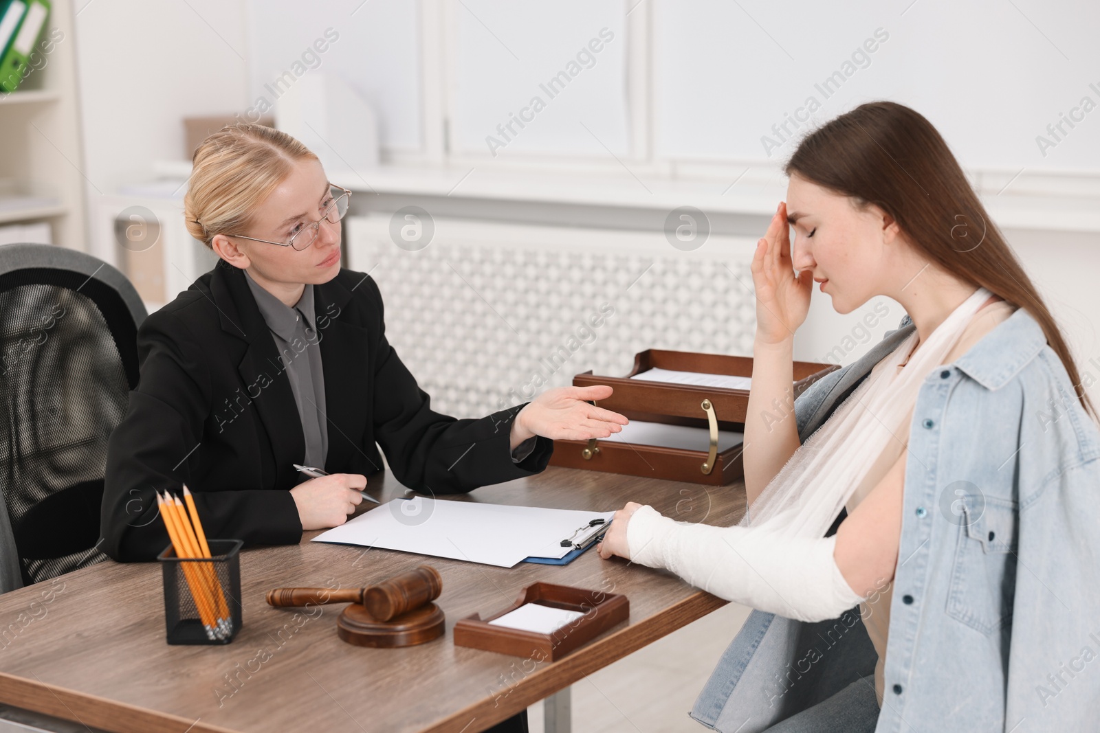 Photo of Injured woman having meeting with lawyer in office