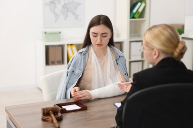 Photo of Injured woman having meeting with lawyer in office