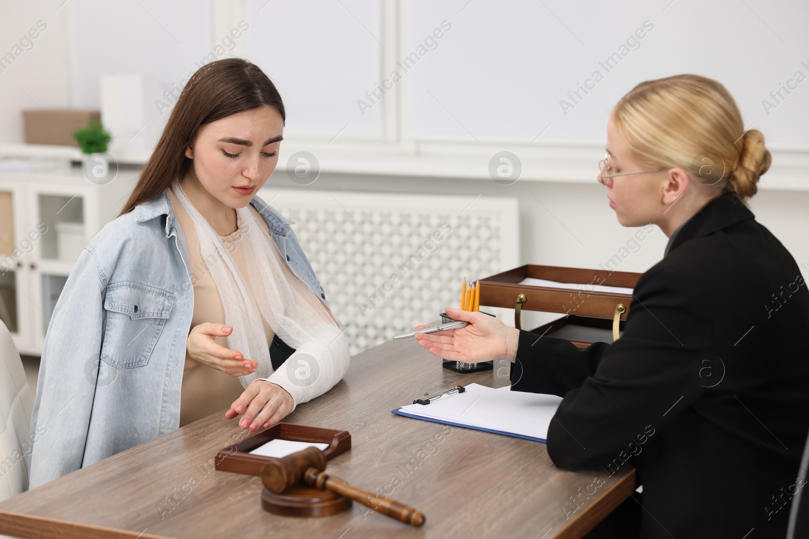 Photo of Injured woman having meeting with lawyer in office