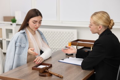 Photo of Injured woman having meeting with lawyer in office