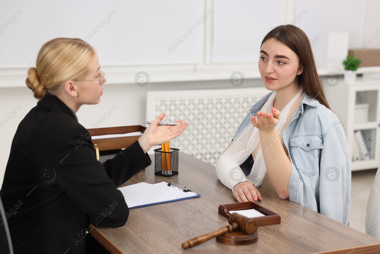 Photo of Injured woman having meeting with lawyer in office