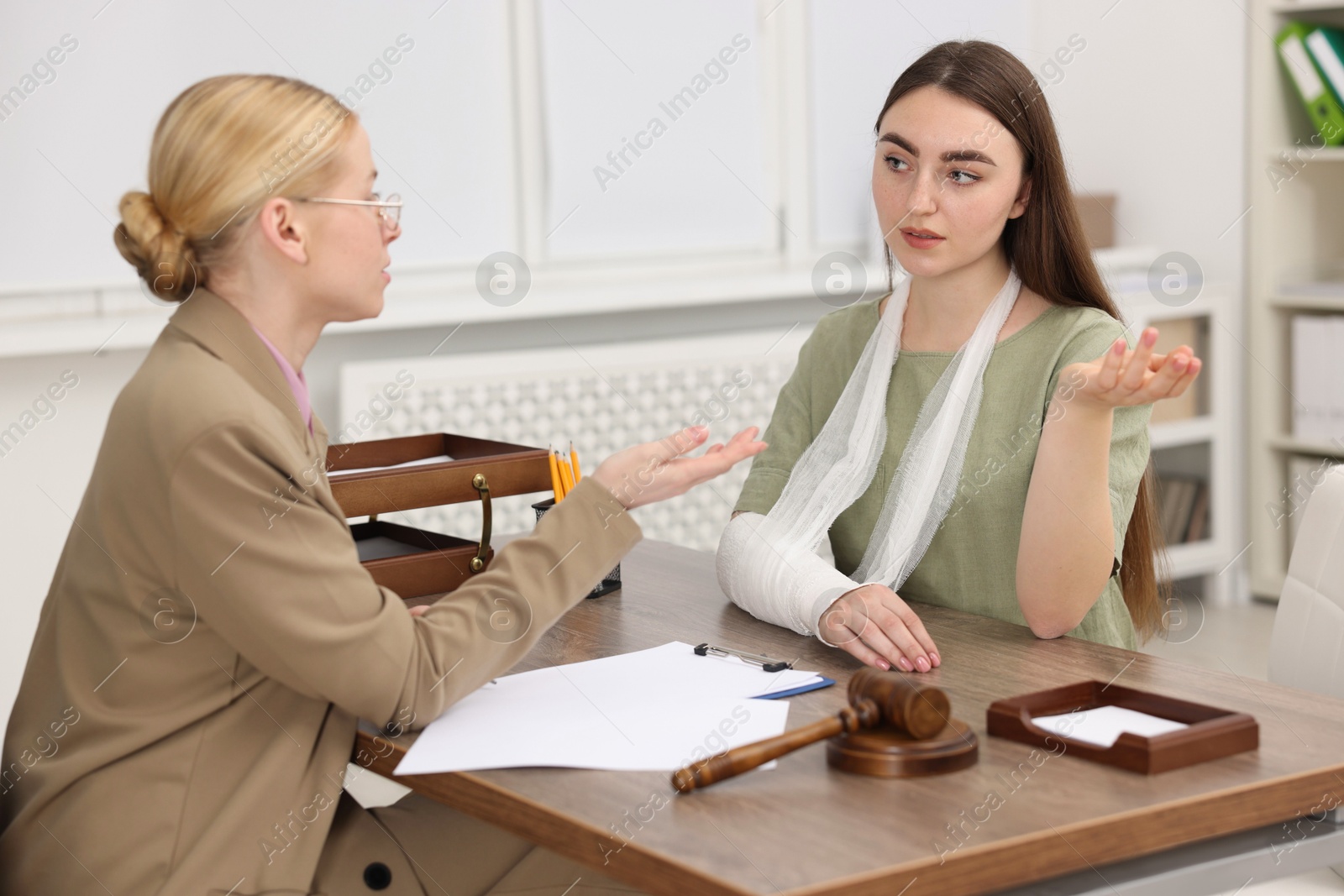 Photo of Injured woman having meeting with lawyer in office