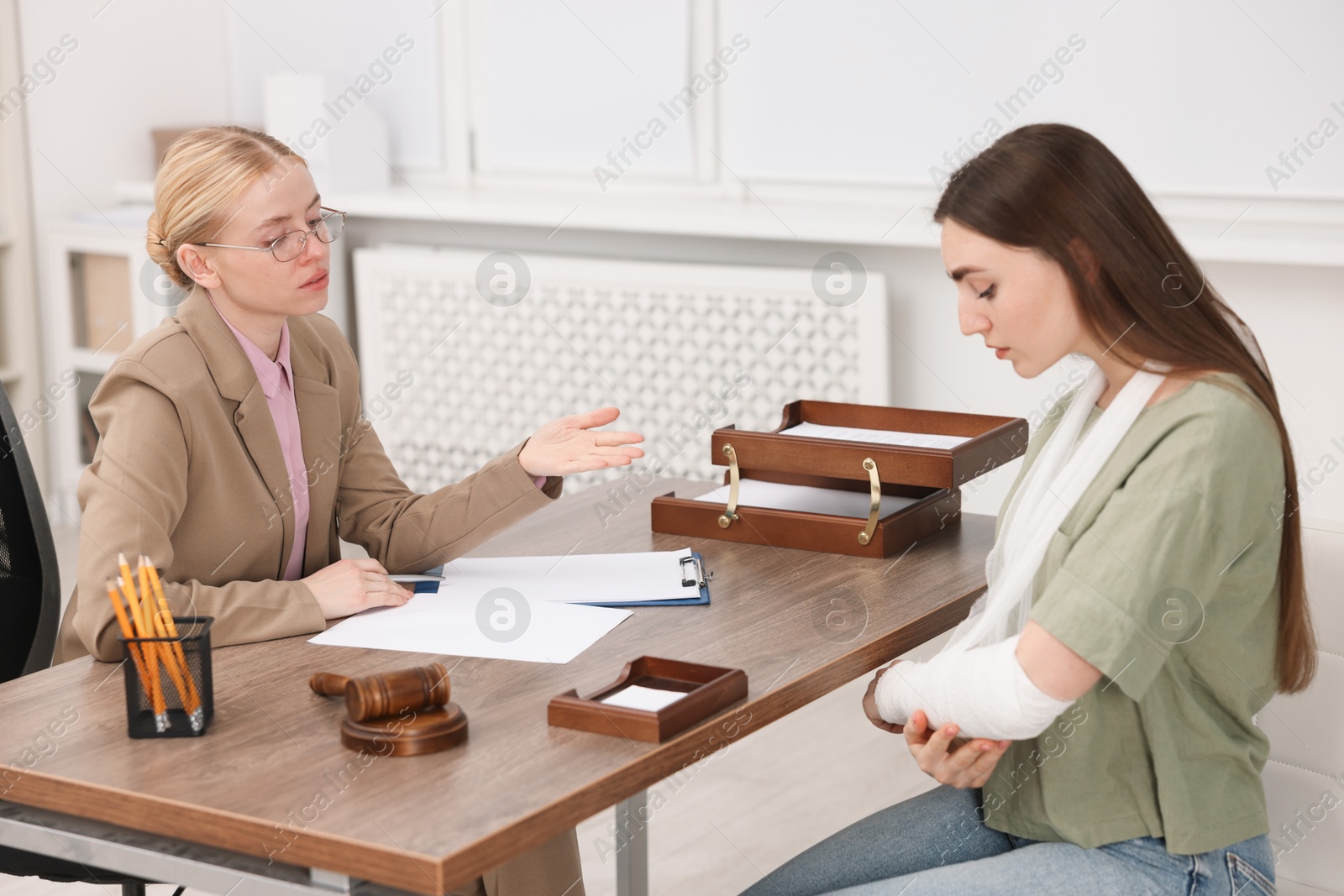 Photo of Injured woman having meeting with lawyer in office