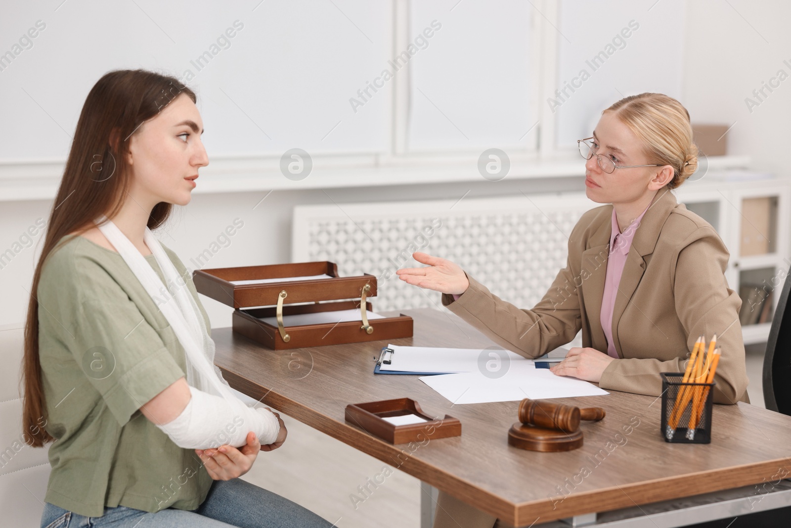 Photo of Injured woman having meeting with lawyer in office