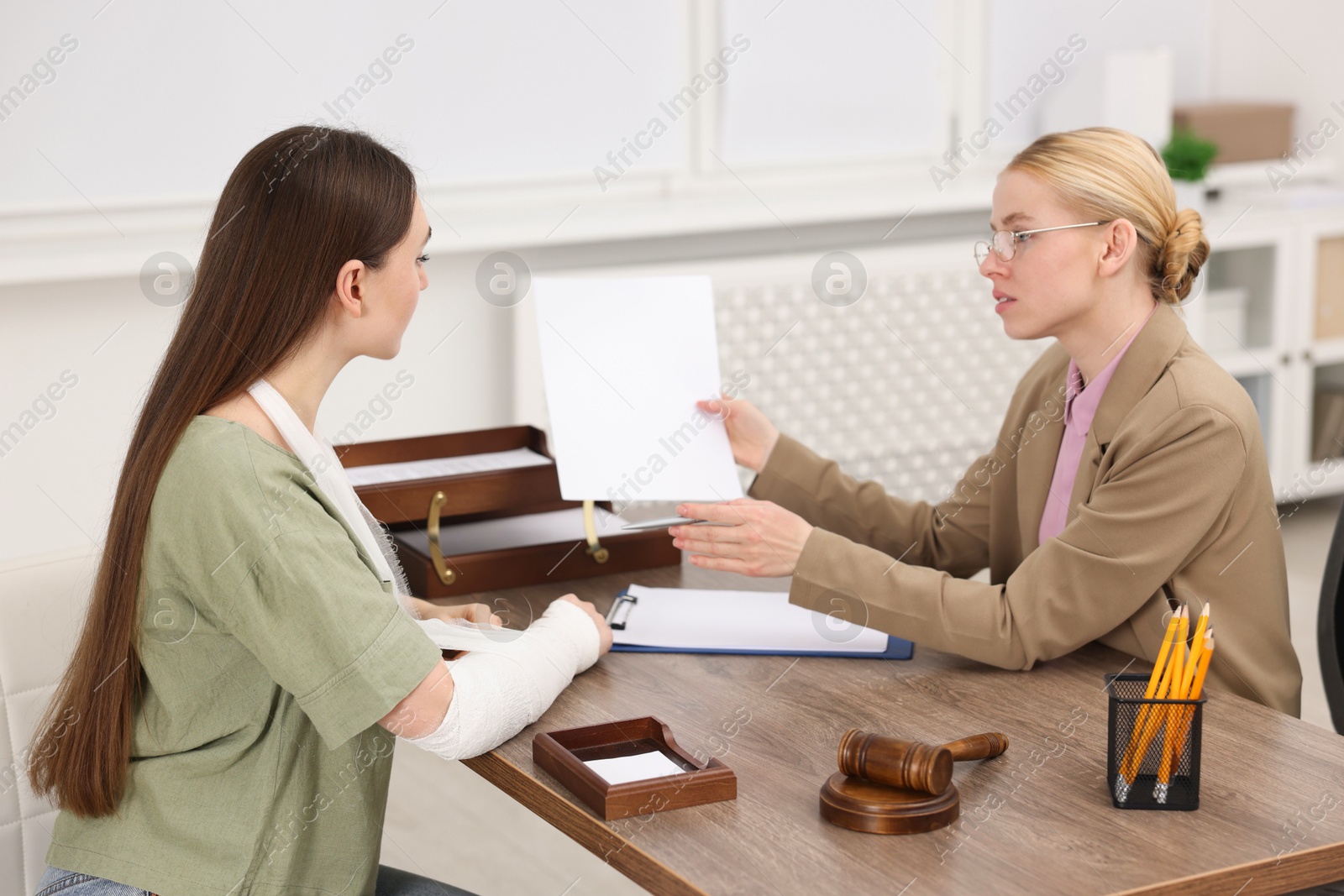 Photo of Injured woman having meeting with lawyer in office