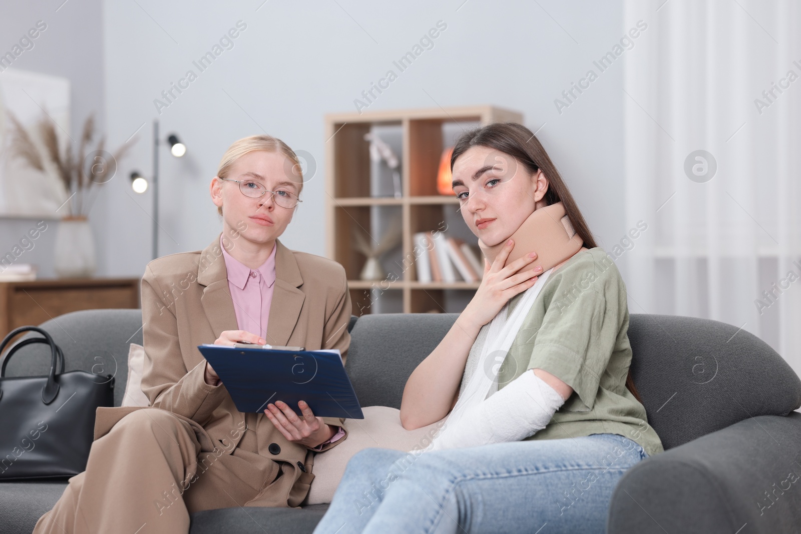 Photo of Injured woman and lawyer with clipboard in office