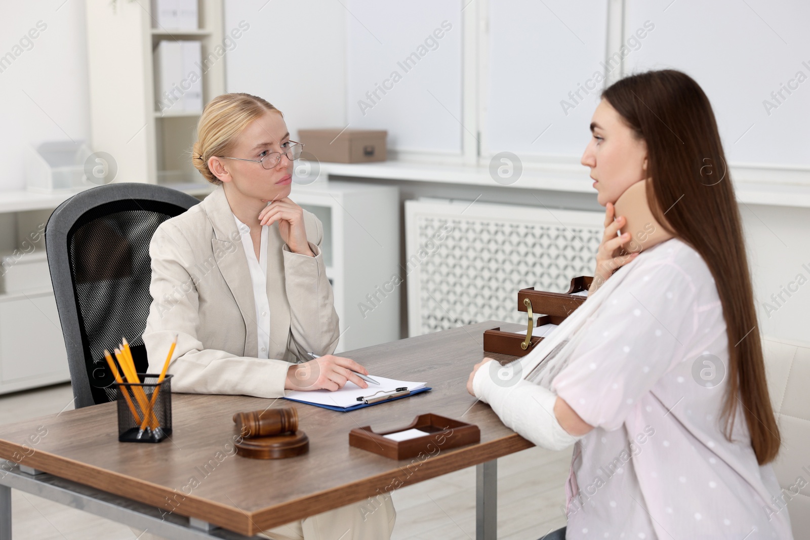 Photo of Injured woman having meeting with lawyer in office