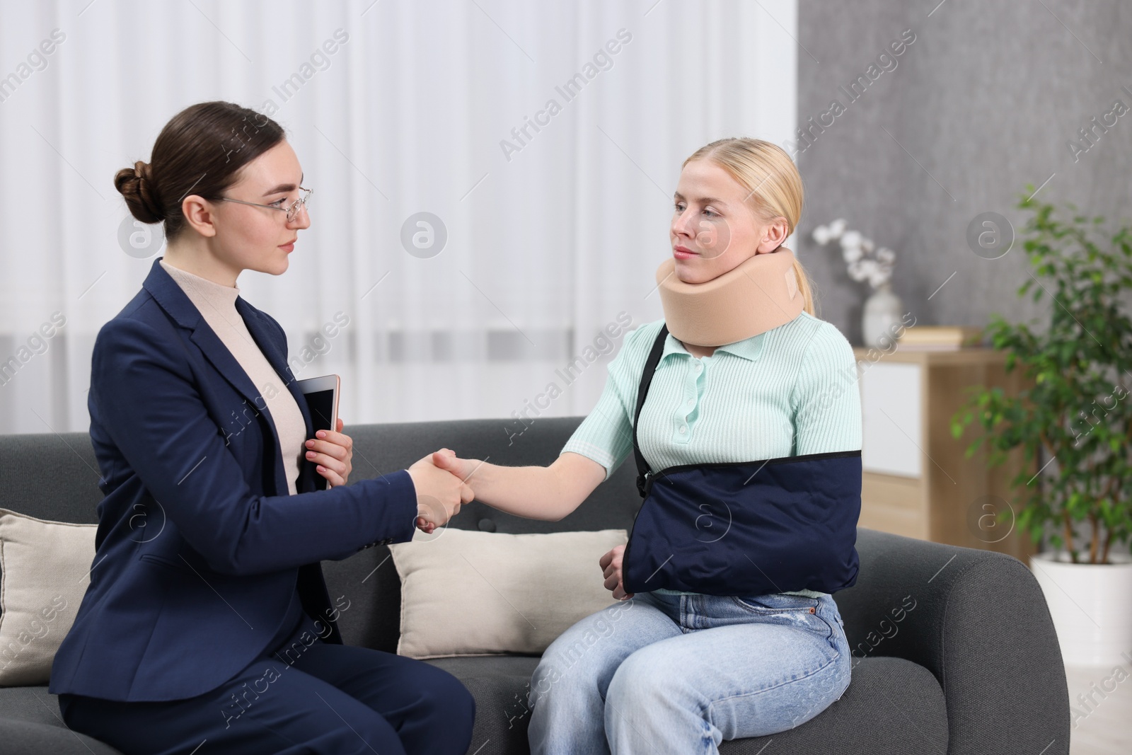 Photo of Injured woman and lawyer shaking hands in office