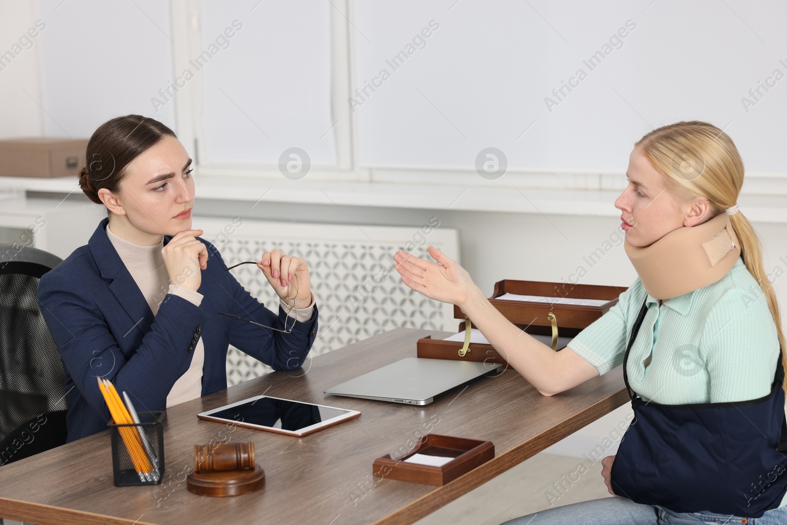 Photo of Injured woman having meeting with lawyer in office