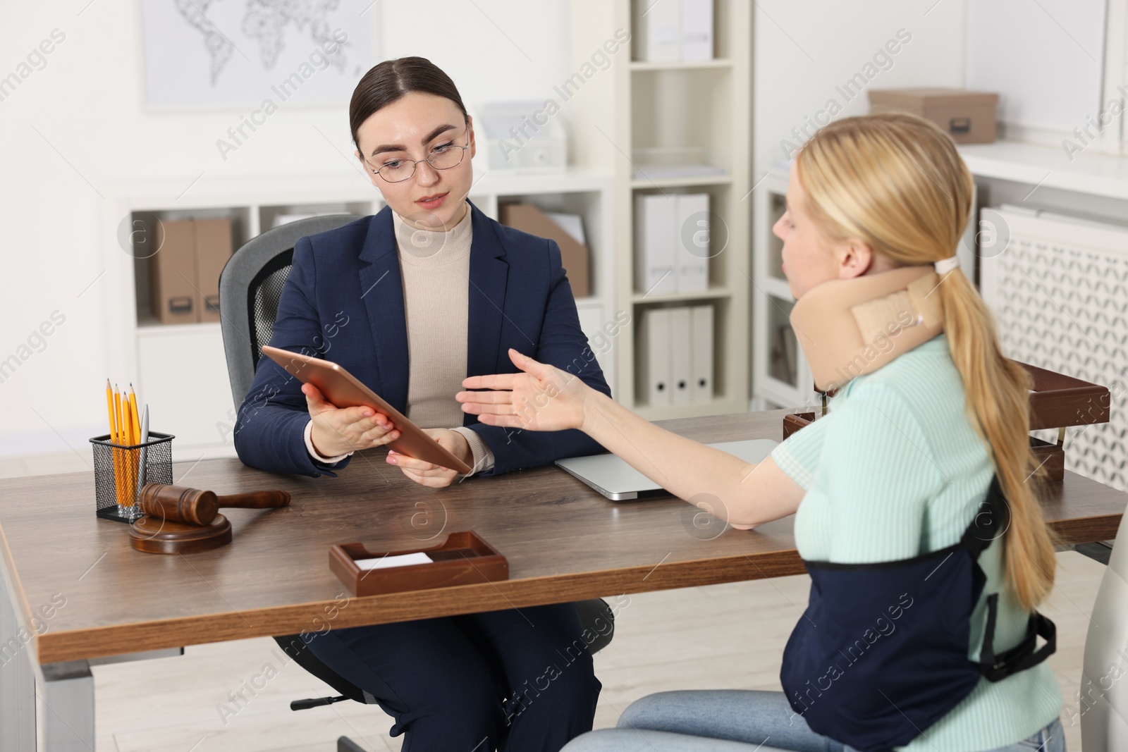 Photo of Injured woman having meeting with lawyer in office, selective focus