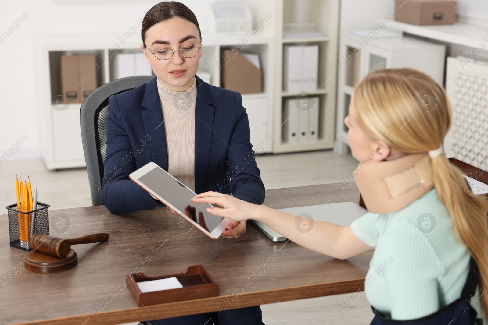 Photo of Injured woman having meeting with lawyer in office, selective focus