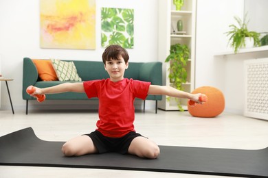 Photo of Boy training with dumbbells at home. Sport activity