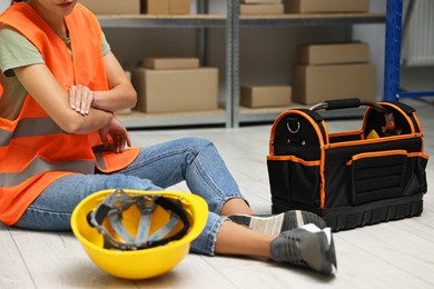 Photo of Accident at work. Woman with injured elbow on floor indoors, closeup